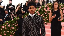 Pembalap Mercedes, Lewis Hamilton berpose saat tiba menghadiri Met Gala 2019 di Metropolitan Museum of Art di New York, AS (6/5/2019). (AFP Photo/Jamie McCarthy)