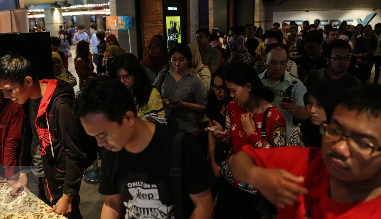 Ratusan orang mengantri untuk mendapatkan tiket nonton bareng Minions yang diselenggarakan oleh CinemaHolic di Blitz Megaplex, Jakarta, Minggu (28/6/2015). (Liputan6.com/Faizal Fanani)