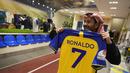Seorang pria memegang kaus Cristiano Ronaldo di toko klub Al Nassr di Riyadh, Arab Saudi, Senin, 2 Januari 2023. Ronaldo menandatangani kontrak dengan Al Nassr dari Arab Saudi pada 31 Desember 2022. Demikian pengumuman klub dalam kesepakatan yang diyakini bernilai lebih dari 200 juta euro. Pemain berusia 37 tahun itu meneken kontrak hingga Juni 2025. (AP Photo/Amr Nabil)