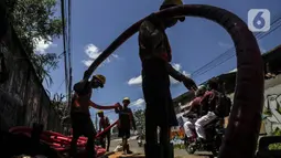 Pekerja informal melakukan pengerjaan menarik kabel di Jakarta, Kamis (2/12/2021). Kemnaker memiliki komitmen serta perhatian tinggi terhadap penanganan dan perlindungan tenaga kerja pada sektor formal dan informal pada masa pandemi Covid-19. (Liputan6.com/Johan Tallo)