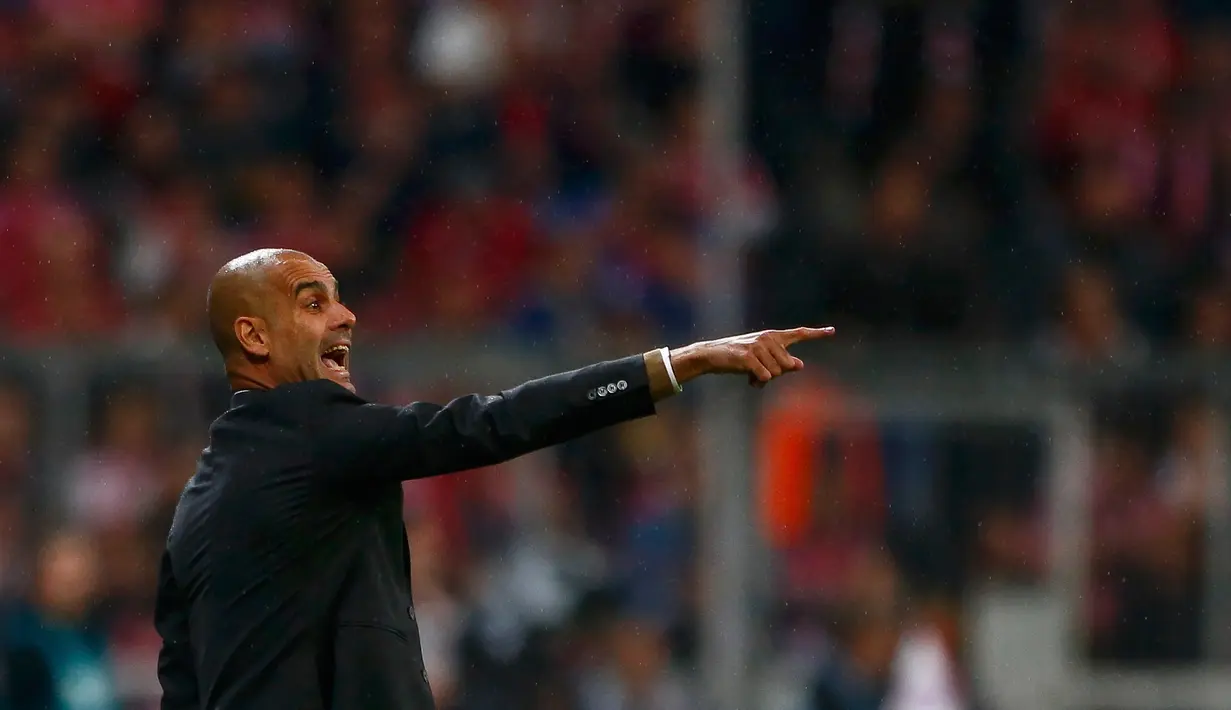 Pelatih Muenchen, Pep Guardiola memberikan arahan pada pemainnya saat bertanding melawan Wolfsburg pada bundesliga di Allianz Arena, Rabu (23/9/2015). Muenchen menang telak atas Wolfsburg dengan skor 5-1. (AFP PHOTO/Michaela Rehle)