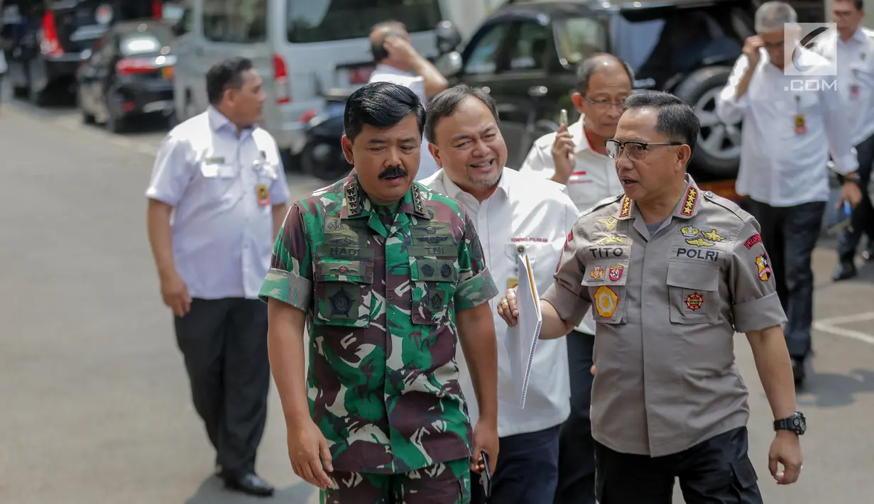 Panglima TNI Marsekal Hadi Tjahjanto (kiri) berbincang dengan Kapolri Tito Karnavian (kanan) saat akan memberi keterangan usai rapat koordinasi tertutup di Kantor Kemenko Polhukam, Jakarta, Selasa (24/9/2019). Ada tiga isu nasional yang dibahas dalam rapat tersebut. (Liputan6.com/Faizal Fanani)