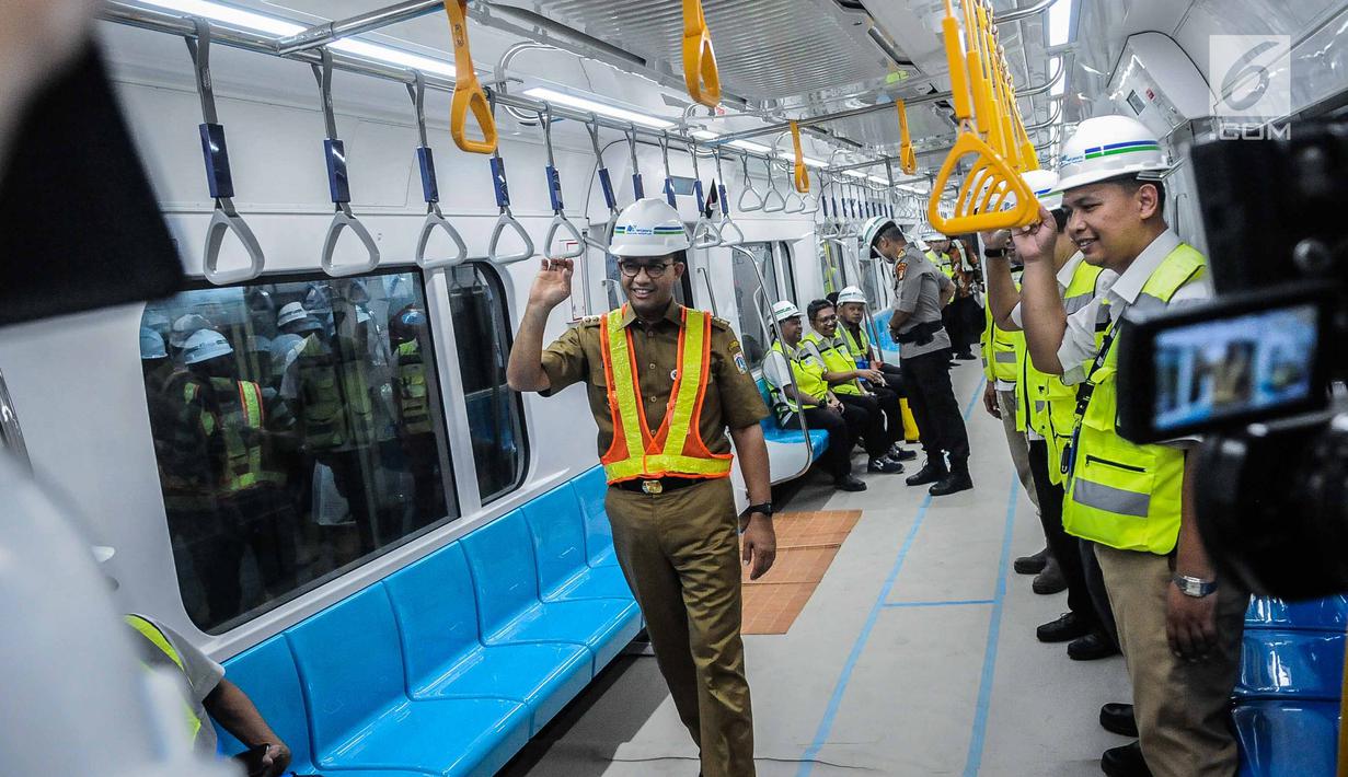 Gubernur DKI Jakarta Anies Baswedan mencoba Moda Raya Terpadu (MRT) dari Stasiun Bundaran HI-Lebak Bulus, Jakarta, Senin (10/12). Anies bersama rombongan harus memakai alat pelindung diri (APD) sepeti sepatu, rompi hingga helm. (Liputan6.com/FaizalFanani)