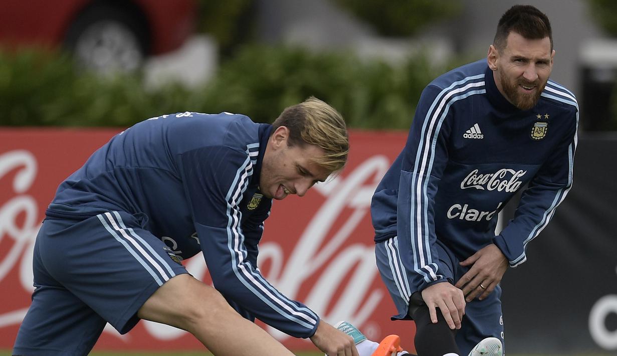 Lionel Messi (kanan) dan Lucas Biglia melakukan pemanasan saat sesi latihan jelang laga kualifikasi Piala Dunia 2018 di Ezeiza, Buenos Aires, (3/10/2017).  Argentina saat ini berada pada peringkat kelima klasemen. (AFP/Juan Mabromata)
