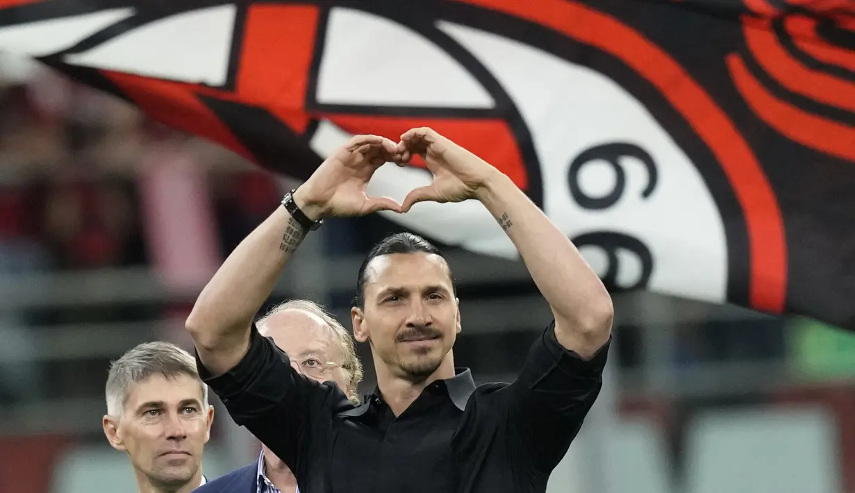 Pemain AC Milan, Zlatan Ibrahimovic, memberikan isyarat cinta kepada ribuan suporter setelah memberikan pidato perpisahannya dari dunia sepakbola di San Siro, Senin (5/6/2023) dini hari WIB. (AP Photo/Antonio Calanni)