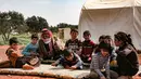 Abderrazaq Khatoun, beristirahat dengan 11 cucunya yang yatim piatu di luar tenda di desa Harbanoush, di Idlib, Suriah pada 11 Maret 2021. Perang Suriah yang merampas 13 anak Khatoun dan salah satu istrinya, membuat kakek 83 tahun itu membesarkan 11 cucu yatim piatu sendirian. (Ahmad al-ATRASH/AFP)