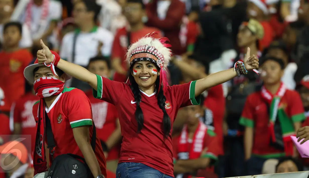 Suporter wanita membentangkan tangan jelang menyaksikan laga final pertama Piala AFF 2016 antara Indonesia melawan Thailand di Stadion Pakansari, Kab Bogor, Rabu (14/12). Indonesia unggul 2-1 atas Thailand. (Liputan6.com/Helmi Fithriansyah)