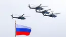 Helikopter militer Rusia mengibarkan bendera nasional Rusia saat parade militer Hari Kemenangan di Moskow, Rusia, Minggu (9/5/2021). Parade militer ini untuk memperingati 76 tahun berakhirnya Perang Dunia II di Eropa. (AP Photo/Alexander Zemlianichenko Jr.)