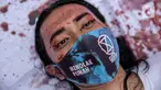 Aktivis melakukan teatrikal dengan menyiramkan darah di tubuhnya saat aksi serentak desak Presiden Jokowi deklarasikan Darurat Iklim di kawasan Patung Kuda, Jakarta, Jumat (19/3/2021). Aksi ini sebagai simbol banyaknya bencana yang terjadi di Indonesia. (Liputan6.com/Faizal Fanani)