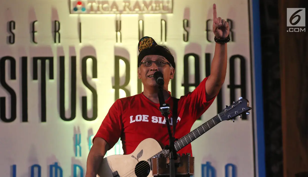 Penyanyi Iwan Fals membawakan lagu sambil bermain gitar dalam Seri Konser Situs Budaya di Panggung Kita, Depok, Sabtu (3/3). Dalam konser tersebut, Iwan Fals membawakan lagu-lagu daerah seperti Tegining Amaq dan Sarompi Mpida. (Liputan6.com/Arya Manggala)