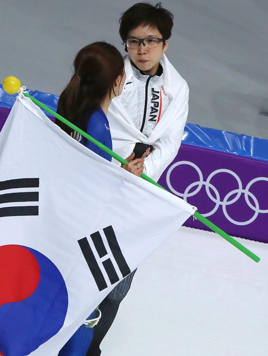 Peraih medali emas, skater Nao Jepang Kodaira memeluk dan memberikan dukungan kepada skater Korsel Lee Sang Hwa yang menangis tersedu karena hanya mendapatkan medali perak di Olimpiade Musim Dingin Pyeongchang 2018, Minggu (18/2). (AP/Eugene Hoshiko)