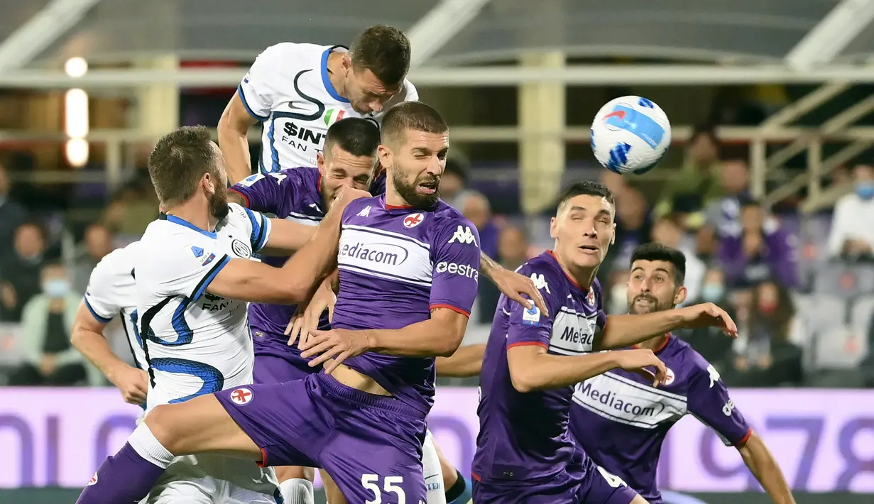 Penyerang Inter Milan Edin Dzeko (atas) mencetak gol ke gawang Fiorentina pada pekan kelima Liga Italia Serie A 2021/2022 di Artemio Franchi, Rabu (22/9/2021) dini hari WIB. Inter Milan menang 3-1 meski sempat tertinggal lebih dulu di babak pertama. (Alfredo Falcone/LaPresse via AP)