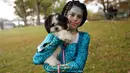 Seekor anjing dan pemiliknya dalam kostum terlihat selama Parade Tompkins Square Halloween Dog di New York, 27 Oktober 2018. Anjing dengan kostum yang paling unik akan dinobatkan sebagai pemenang dan mendapat hadiah dari panitia. (TIMOTHY A. CLARY / AFP)