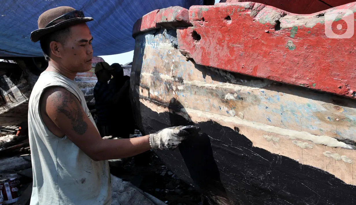 Pekerja menyelesaikan proses perbaikan kapal nelayan di pesisir Marunda, Jakarta, Selasa (22/10/2019). Untuk jasa perbaikan satu buah kapal biasanya dipatok dengan harga Rp 15 juta dalam waktu pengerjaan hingga sebulan. (merdeka.com/Iqbal Nugroho)