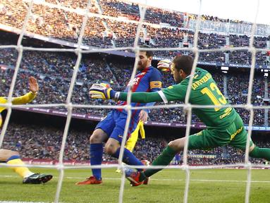 Pemain FC Barcelona, Lionel Messi (tengah) mengecoh kiper dan pemain Las Palmas saat mencetak gol pada laga La Liga di Camp Nou, Barcelona (14/1/2017). Barcelona menang 5-0. (AP/Manu Fernandez)