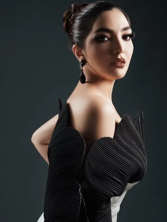 Ashanty tampil sangat menawan dalam balutan gaun hitam dan makeup bold bernuansa cokelat yang dark. Rambutnya digulung untuk mendapatkan sleek look. Foto: Instagram.