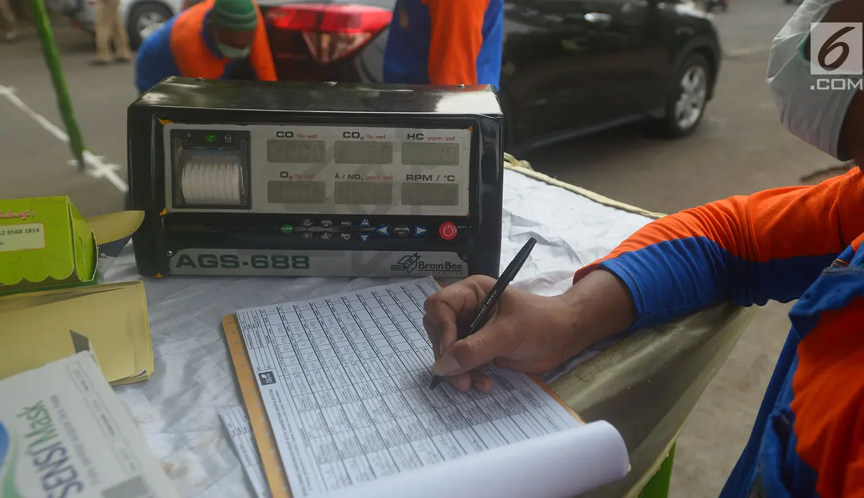 Petugas mengisi form uji emisi gas buang kendaraan di Kalibata, Jakarta, Rabu (24/7). Uji emisi kendaraan di lakukan untuk kadar kualitas udara perkotaan, seiring meningkatnya volume kendaraan bermotor di kota-kota besar. (Merdeka.com/Imam Buhori)
