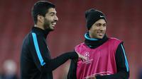 Penyerang Barcelona, Luis Suarez (kiri) dan Neymar berbincang saat sesi latihan di Emirates Stadium, Inggris, (23/2). Barcelona akan bertanding melawan Arsenal di leg pertama 16 besar Liga Champions. (Reuters/Matius Childs)