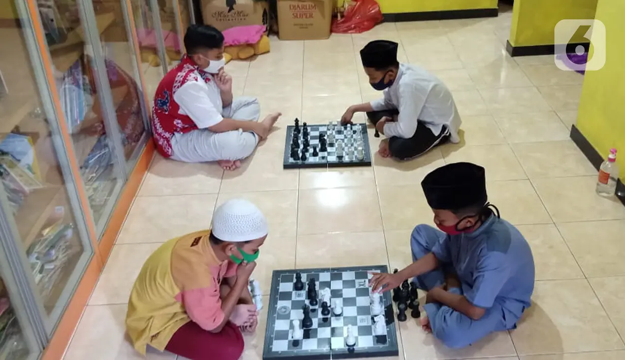 Anak-anak bermain catur di Rumah Amalia, Kota Tangerang, Selasa (23/03/2021). Kegiatan mengisi waktu usai belajar daring ini bisa mengasah ketelitian,fokus dan juga strategi dalam permainan selama masa pandemi Covid-19. (Liputan6.com/Fery Pradolo)