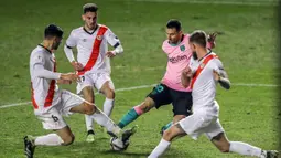 Pemain Barcelona Lionel Messi membawa bola melewati para pemain Rayo Vallecano pada pertandingan 16 besar Copa del Rey di Stadion Vallecas, Madrid, Spanyol, Rabu (27/1/2021). Barcelona melaju ke perempat final Copa del Rey usai mengalahkan Rayo Vallecano 2-1. (AP Photo/Manu Fernandez)