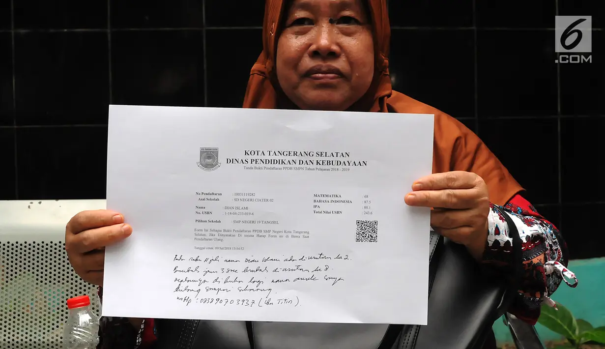 Orang tua wali murid menunjukkan tanda bukti pendaftaran PPDB di posko SMP 11 Rawa Buntu, Serpong, Tangsel, Jumat (13/07). Mereka protes karena tidak bisa mengetahui kelanjutan hasil pendaftaran putra-putrinya lewat situs PPDB. (Merdeka.com/Arie Basuki)