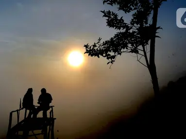 Pengunjung menunggu hilangnya kabut yang menutupi kawasan Gunung Luhur di Desa Citorek Kidul, Kecamatan Cibeber, Kabupaten Lebak, Banten, Sabtu (23/11/2019). Wisata “Negeri Di Atas Awan” yang sempat tutup sementara sejak September 2019 lalu ini kembali ramai oleh wisawatan. (merdeka.com/Arie Basuki)