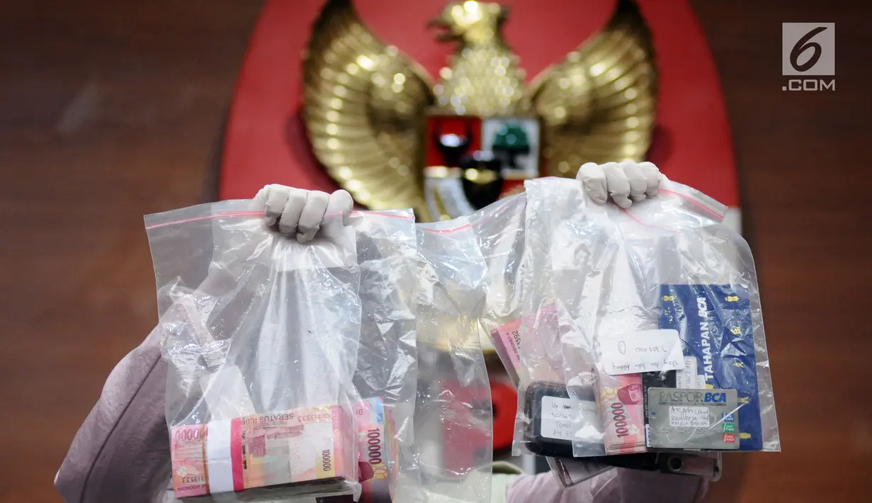 Petugas menunjukkan barang bukti hasil OTT kasus dugaan penyuapan pembahasan perda penyertaan modal Kota Banjarmasin ke PDAM di Gedung KPK, Jakarta, Jumat (15/9). KPK memeriksa empat orang diduga tersangka. (Liputan6.com/Helmi Fithriansyah)