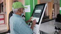 Salah seorang warga sedang mendaftar untuk berobat di mesin anjungan mandiri UPTD Puskesmas Beji, Depok. (Dokumen Diskominfo Kota Depok)