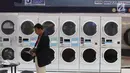 Penjaga stan melintas di depan mesin cuci di pameran Expo Clean dan Expo Laundry 2018, Jakarta, Selasa (27/3). Pameran tersebut merupakan pameran dagang yang menampilkan produk dan jasa dalam industri cleaning dan laundry. (Liputan6.com/Angga Yuniar)