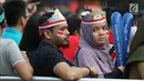 Calon penonton menggunakan hiasan saat antre masuk menyaksikan laga final bulu tangkis beregu putra di Istora Senayan Jakarta, Rabu (22/8). Laga final bulu tangkis beregu putra mempertemukan Indonesia melawan China. (Liputan6.com/Helmi Fithriansyah)