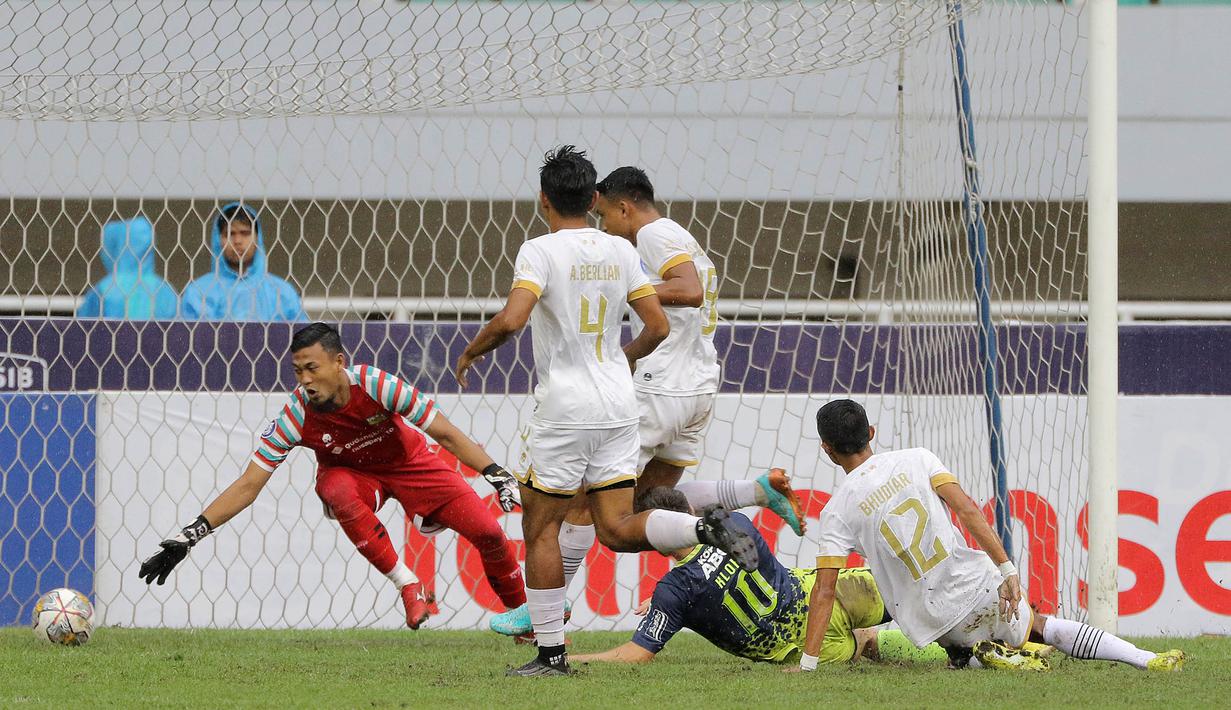 Penjaga gawang Dewa United, M Natshir Fadhil Mahbuby (kiri), gagal menghalau bola sontekan dari pemain Persib Bandung, Marc Klok yang membuahkan gol dalam pertandingan pekan ke-31 BRI Liga 1 2022/2023 yang berlangsung di stadion Pakansari, Cibinong, Senin (20/3/2023). (Bola.com/Ikhwan Yanuar)