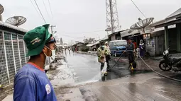 Petugas membersihkan jalanan yang tertutup abu vulkanik Gunung Sinabung di Karo, Sumatra Utara (19/2). Gunung Sinabung kembali aktif pada tahun 2010 untuk pertama kalinya sejak 400 tahun terakhir. (AFP Photo/Ivan Damanik)