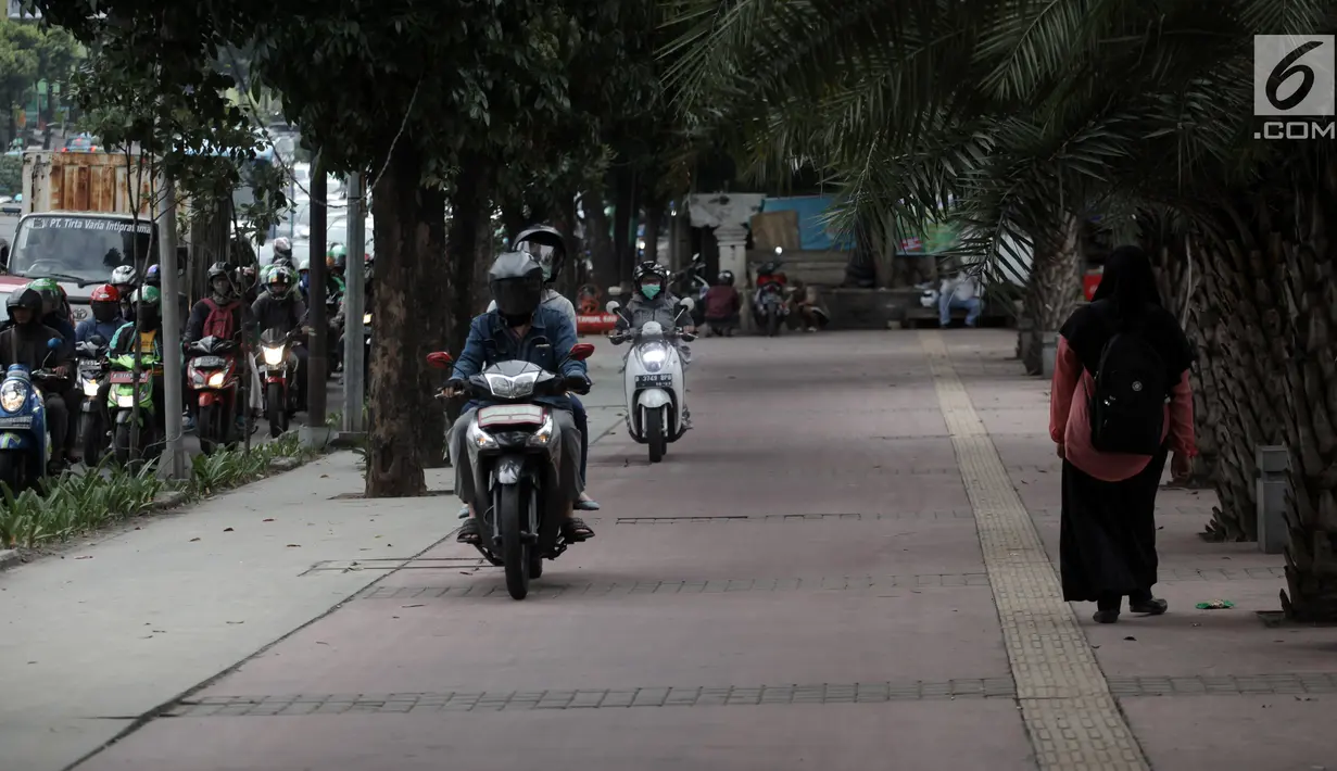 Pengendara sepeda motor nekat menaiki jalur trotoar untuk menghindari kemacetan di Jalan Casablanca, Jakarta, Senin (8/1). Tindakan tersebut memaksa pejalan kaki untuk berjalan di tepi trotoar. (Liputan6.com/Arya Manggala Nuswantoro)