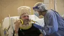 Nazzareno Santilli, 60 tahun, menghirup ventilasi tutup kepala oksigen CPAP tersenyum kembali kepada Dr. Elisabetta Teti di unit COVID-19 sub-intensif Rumah Sakit Poliklinik Tor Vergata, di Roma, 7 November 2020. (AP Photo/Alessandra Tarantino)