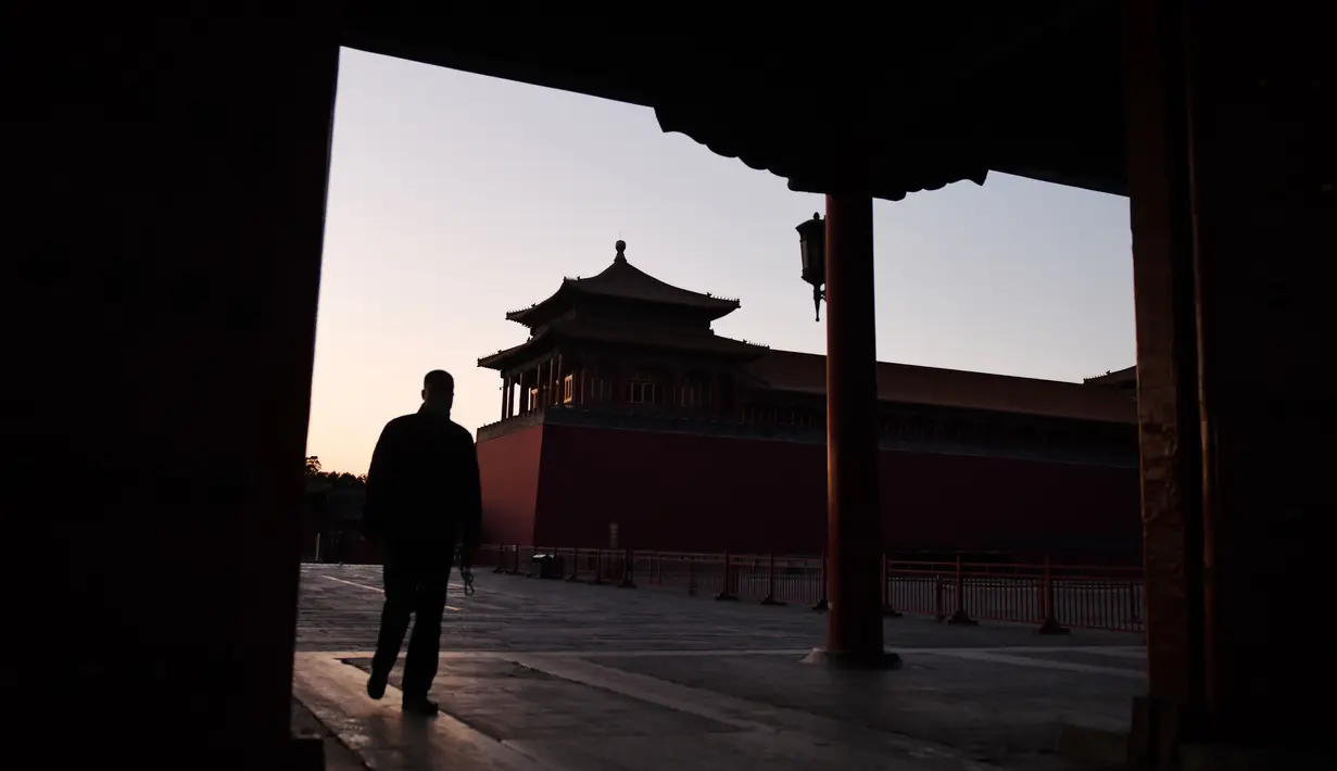 Seorang pria berjalan melewati Forbidden City atau Kota Terlarang yang ditutup di Beijing pada Selasa (4/2/2020). Mencegah korban virus corona bertambah, China menutup  banyak destinasi wisata termasuk Kota Terlarang yang ditutup untuk kunjungan wisatawan sejak 24 Januari 2020 lalu. (GREG BAKER/AFP)