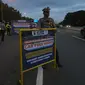 Petugas dari Polres Bogor memasang rambu penutupan jalan di pintu keluar Tol Gadog, Bogor, Sabtu (31/12/2022). Penutupan jalan jalur Puncak Bogor untuk gelaran Car Free Night dimulai sejak pukul 18.00 WIBdan dibuka kembali esok pagi pukul 06.00 WIB. (merdeka.com/Arie Basuki)