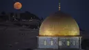 Bulan purnama terbesar atau supermoon terbit di balik kuil Dome of the Rock di kompleks Masjid Al Aqsa di Kota Tua Yerusalem, Senin, 19 Agustus 2024. (AP Photo/Leo Correa)