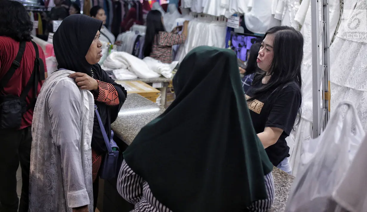 Pengunjung mencoba busana muslim di Pasar Tanah Abang Blok A, Jakarta, Minggu (5/5/2019). Warga Jakarta dan sekitarnya sudah mulai memadati kawasan tersebut untuk berbelanja perlengkapan dan kebutuhan menyambut bulan Ramadan. (Liputan6.com/Faizal Fanani)