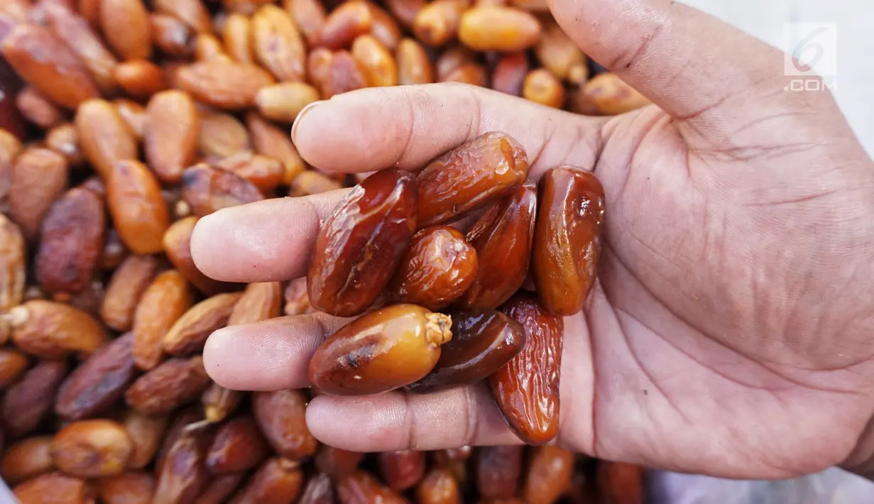 Pedagang kurma menunjukkan barang dagangannya di Pasar Tanah Abang, Jakarta, Kamis (2/5). Menjelang bulan Ramadan, permintaan buah kurma meningkat dua kali lipat dibanding hari biasa. (Liputan6.com/JohanTallo)