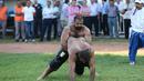 Pertandingan gulat oli ini di pimpin oleh seorang wasit. (AFP Photo/Adem Altan)