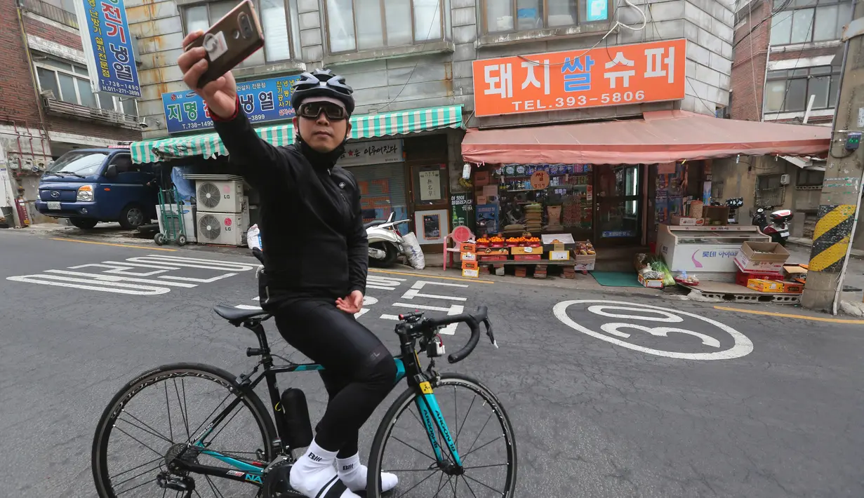 Lee Joon-ho berswafoto dengan latar belakang sebuah supermarket yang muncul dalam film'Parasite' di Seoul, 15 Februari 2020. Lokasi syuting Parasite di Korea Selatan semakin ramai dikunjungi turis setelah film tersebut berhasil memboyong dan mendominasi di penghargaan Oscar 2020. (AP/Ahn Young-joon)