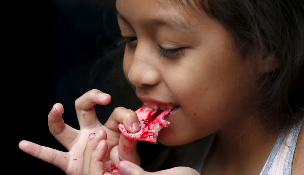 Seorang anak saat memakan permen yang berbentuk organ tubuh manusia di kota Meksiko, Jumat (30/10/2015). Permen dan beraneka jajanan berbentuk organ manusia ini dibuat untuk merayakan hari halloween. (REUTERS/Carlos Jasso) 