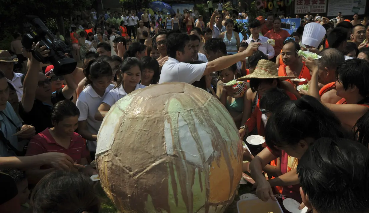  Pengunjung berbagi es krim raksasa berbentuk bola di sebuah resor kolam renang di Tiongkok, Minggu (29/6/14). (REUTERS/Stringer)