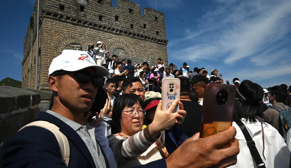 Pengunjung menyusuri anak tangga di Tembok China bersama keluarga maupun teman. (GREG BAKER / AFP)