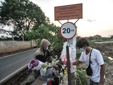 Pedagang saat melayani peziarah yang membeli bunga di TPU Rorotan, Jakarta, Selasa (10/8/2021). Adanya TPU Rorotan yang dikhususkan untuk pemakaman jenazah pasien Covid-19 membawa rezeki baru bagi warga setempat, yakni berjualan bunga bagi peziarah. (merdeka.com/Iqbal S. Nugroho)