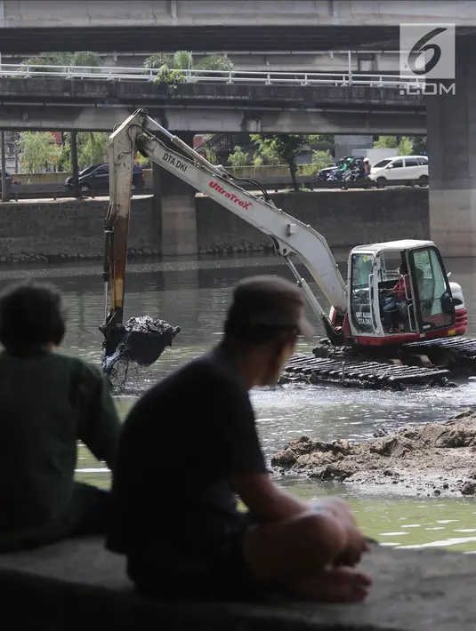 Warga menyaksikan proses pengerukan Waduk Grogol, Jakarta, Senin (9/4). Pengerukan dilakukan guna meningkatkan daya tampung waduk sebagai bagian dari upaya mengatasi banjir. (Liputan6.com/Arya Manggala)