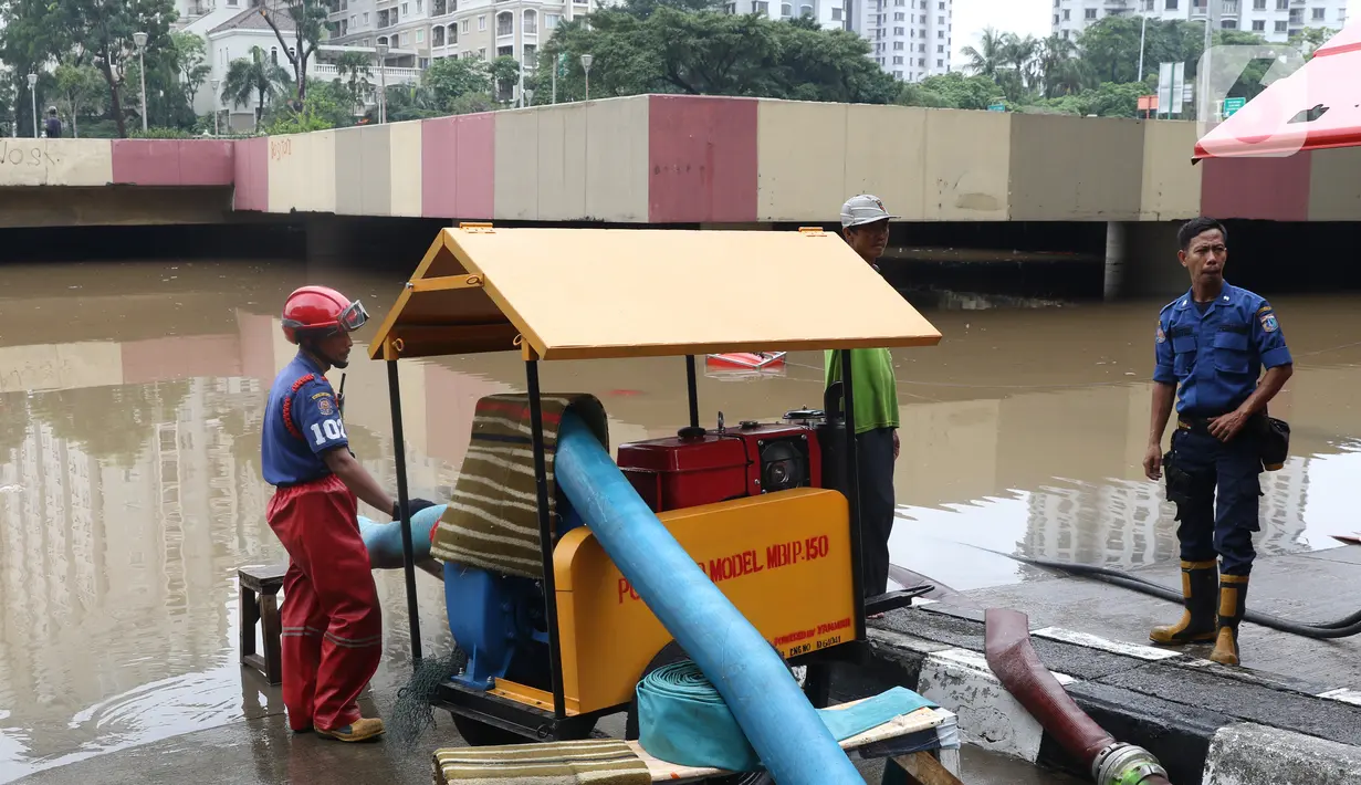 Petugas melakukan penyedotan air yang merendam underpass Kemayoran, Jakarta, Minggu (2/2/2020). Akibat hujan yang cukup lama di kawasan tersebut membuat underpass tersebut terendam air hingga ketinggian 5 meter. (Liputan6.com/Angga Yuniar)