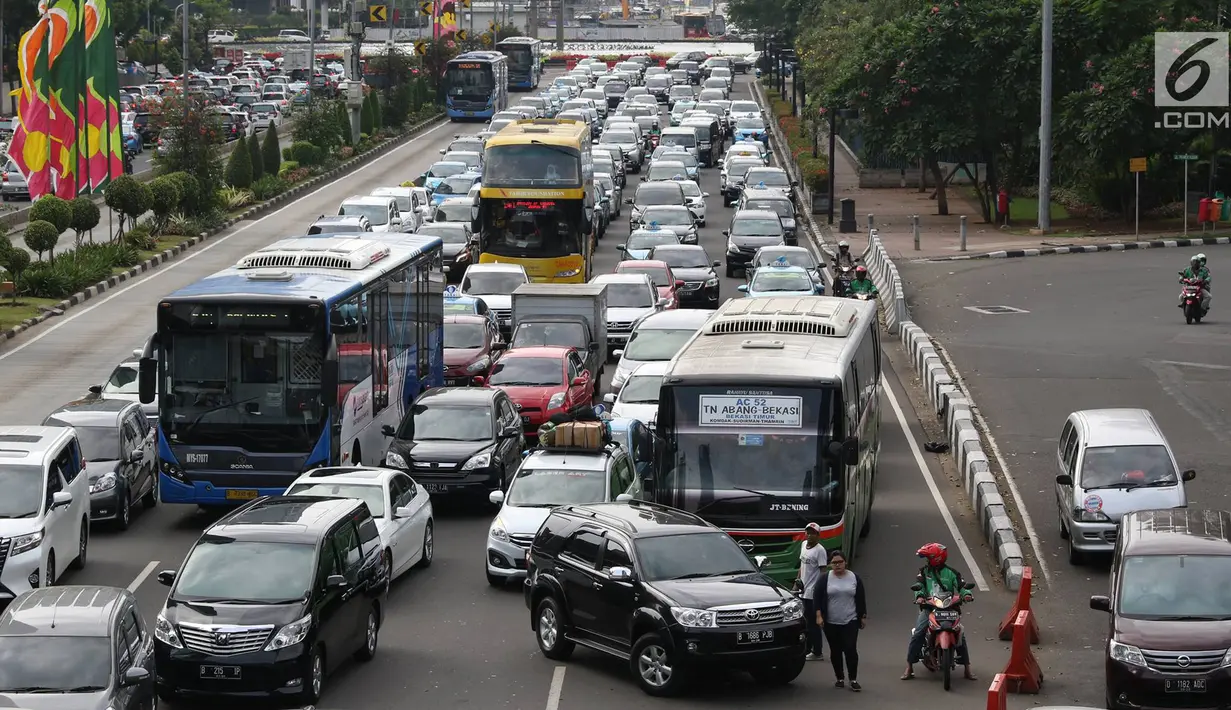 Kendaraan terjebak kemacetan di Jalan Sudirman, Jakarta, Jumat (23/6). Polda Metro Jaya tidak memberlakukan kawasan pengendalian lalu lintas ganjil-genap di beberapa jalan protokol Jakarta saat libur cuti bersama Lebaran. (Liputan6.com/Immanuel Antonius)