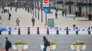 Orang-orang berjalan di sekitar Bund, sepanjang Sungai Huangpu, Puxi, Shanghai, 31 Maret 2022. Daerah Puxi akan lockdown mulai 1 April 2022. (Hector RETAMAL/AFP)