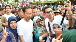 Presiden Joko Widodo (Jokowi) ditemani putra bungsunya, Kaesang Pangarep berjalan-jalan di sepanjang kawasan Malioboro, Yogyakarta, Minggu (31/12). Masyarakat tampak antusias menyambut kedatangan Presiden Jokowi. (LIputan6.com/Biro Setpres)